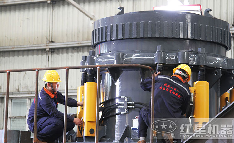 工作人員檢測圓錐破碎機(jī)，保障生產(chǎn)的設(shè)備都有高質(zhì)量